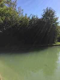 Swimming pool by lake against sky