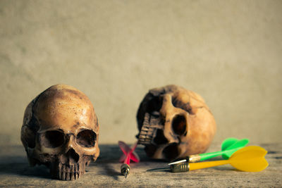 Close-up of human skulls and darts on table