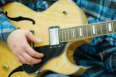 Midsection of man playing guitar