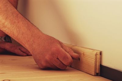 Cropped image of hands attaching wood on wall