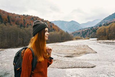 Woman standing on mountain against sky
