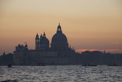 Santa maria della salute by grand canal against sky during sunset in city