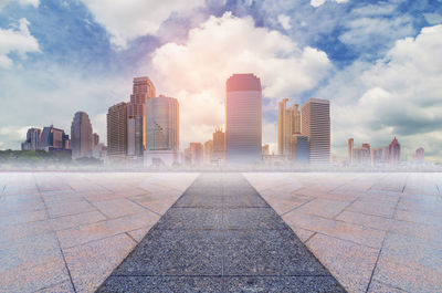 Modern buildings in city against cloudy sky