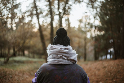 Rear view of man and woman standing on field in forest