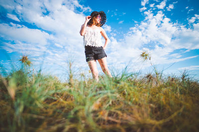 Woman standing on field against sky