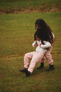 Playful siblings on field at park