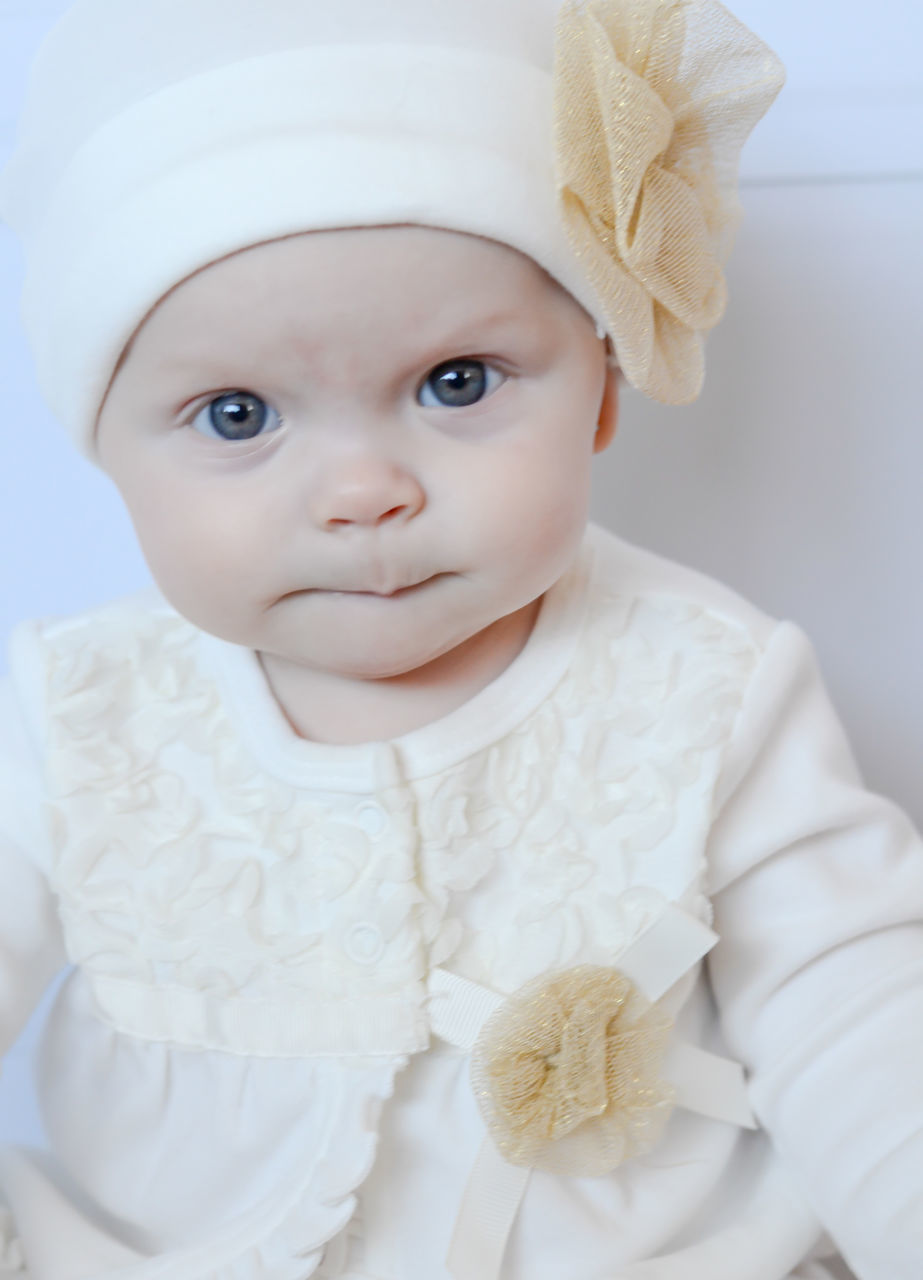 indoors, childhood, looking at camera, portrait, cute, person, innocence, home interior, front view, elementary age, bed, babyhood, girls, casual clothing, lifestyles, close-up, white color, baby