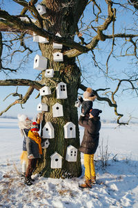 Family standing by birdhouses on tree