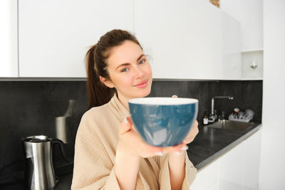 Young woman using mobile phone while sitting at home