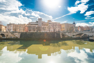 Bridge over river against buildings in city