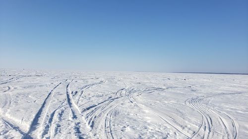 Scenic view of snowcapped landscape against clear blue sky