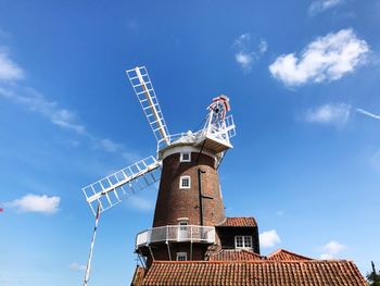 Low angle view of traditional windmill against blue sky