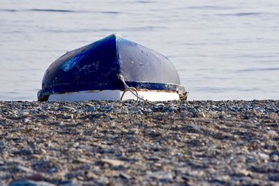 Upside down boat moored at beach