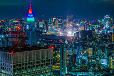 Illuminated cityscape against sky at night