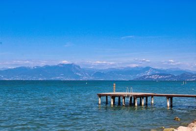 Pier over sea against blue sky