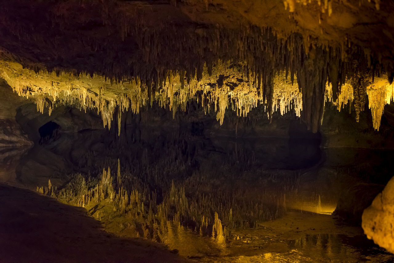 SCENIC VIEW OF ILLUMINATED CAVE IN WATER