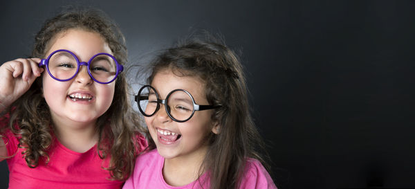 Smiling girls against black background