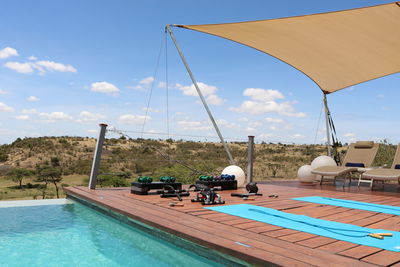 Swimming pool by sea against sky
