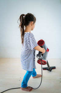 Cute girl cleaning floor with vacuum cleaner