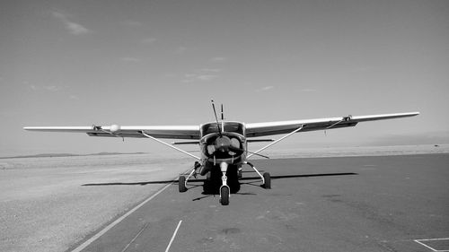 Airplane flying over runway against sky