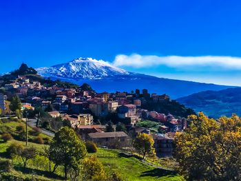 Houses on mountain against blue sky