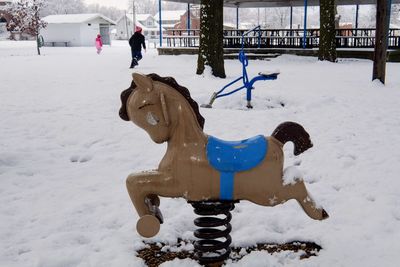 Horse spring ride at snow covered park