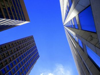 Low angle view of modern building against blue sky