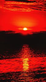 Scenic view of sea against dramatic sky during sunset