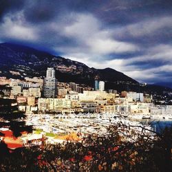 Buildings in town against cloudy sky