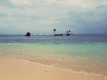 People on beach against sky