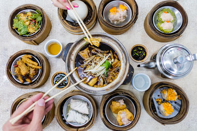 Cropped hand of people using chopstick on table