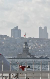 City buildings by sea against sky