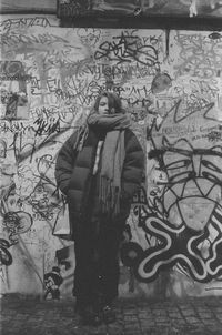 Man standing against graffiti wall