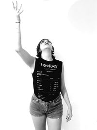 Portrait of young woman standing against white background