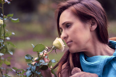 Close-up of woman smelling flowers outdoors