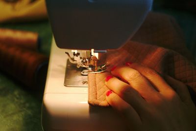 Cropped hand of woman sewing fabric