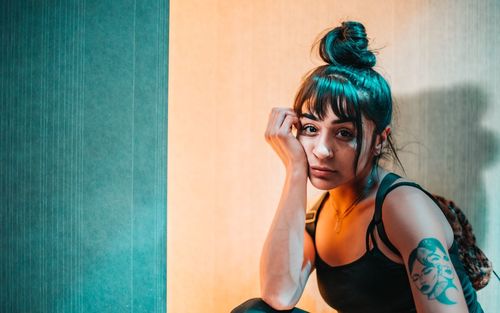 Portrait of young woman against wall