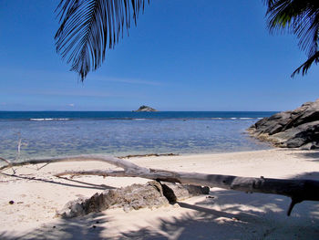 Scenic view of beach against clear blue sky