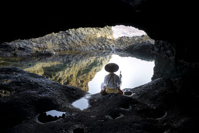 Rear view of man standing on rock formations