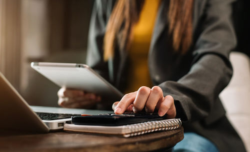 Midsection of woman using laptop