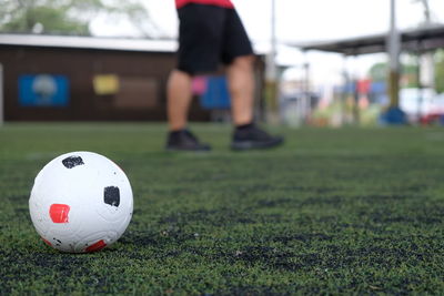 Low section of soccer player with ball on field