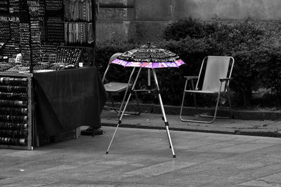 Empty chairs and tables in yard against building