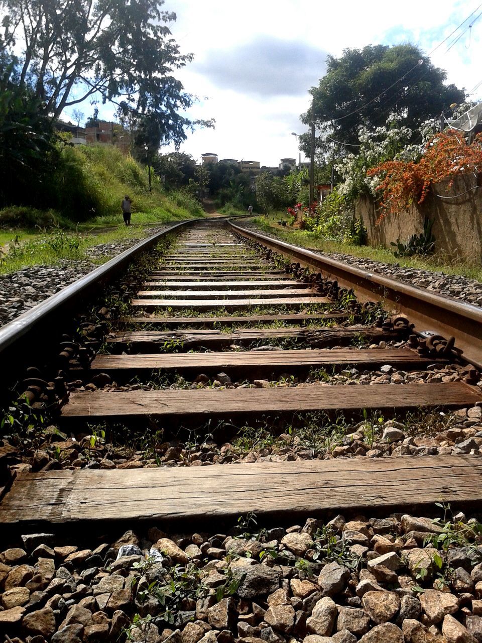 the way forward, railroad track, diminishing perspective, tree, sky, vanishing point, rail transportation, transportation, cloud - sky, tranquility, stone - object, day, growth, railing, nature, tranquil scene, metal, straight, plant, long