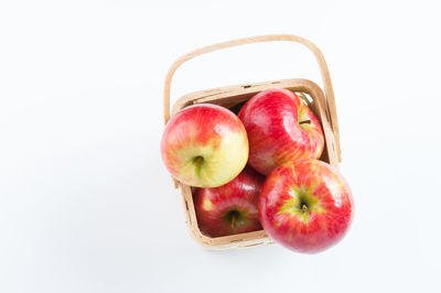Close-up of apples in basket against white background