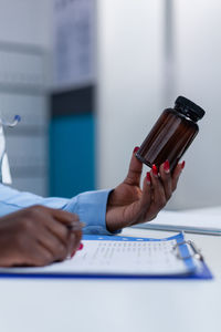 Cropped hand of doctor holding medicine bottle