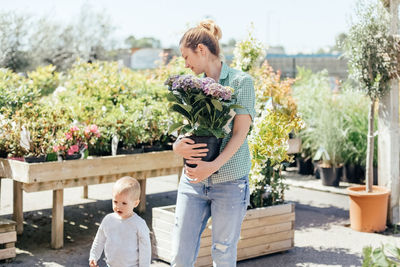 Mother with son buys hydrangea in a pot at a flower shop