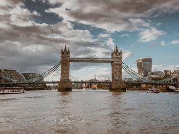 Tower bridge against cloudy sky