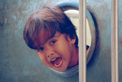 Portrait of boy seen through play equipment