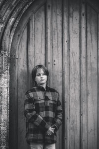 Young woman standing against wall