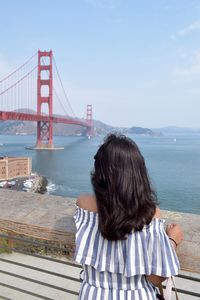 Rear view of woman looking at suspension bridge